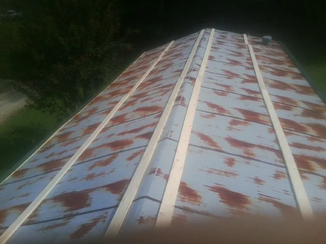 Rusted metal roof panels with new wood purlins before replacement — Storm Damage Roof Repair in Koppel by Roofing Brothers