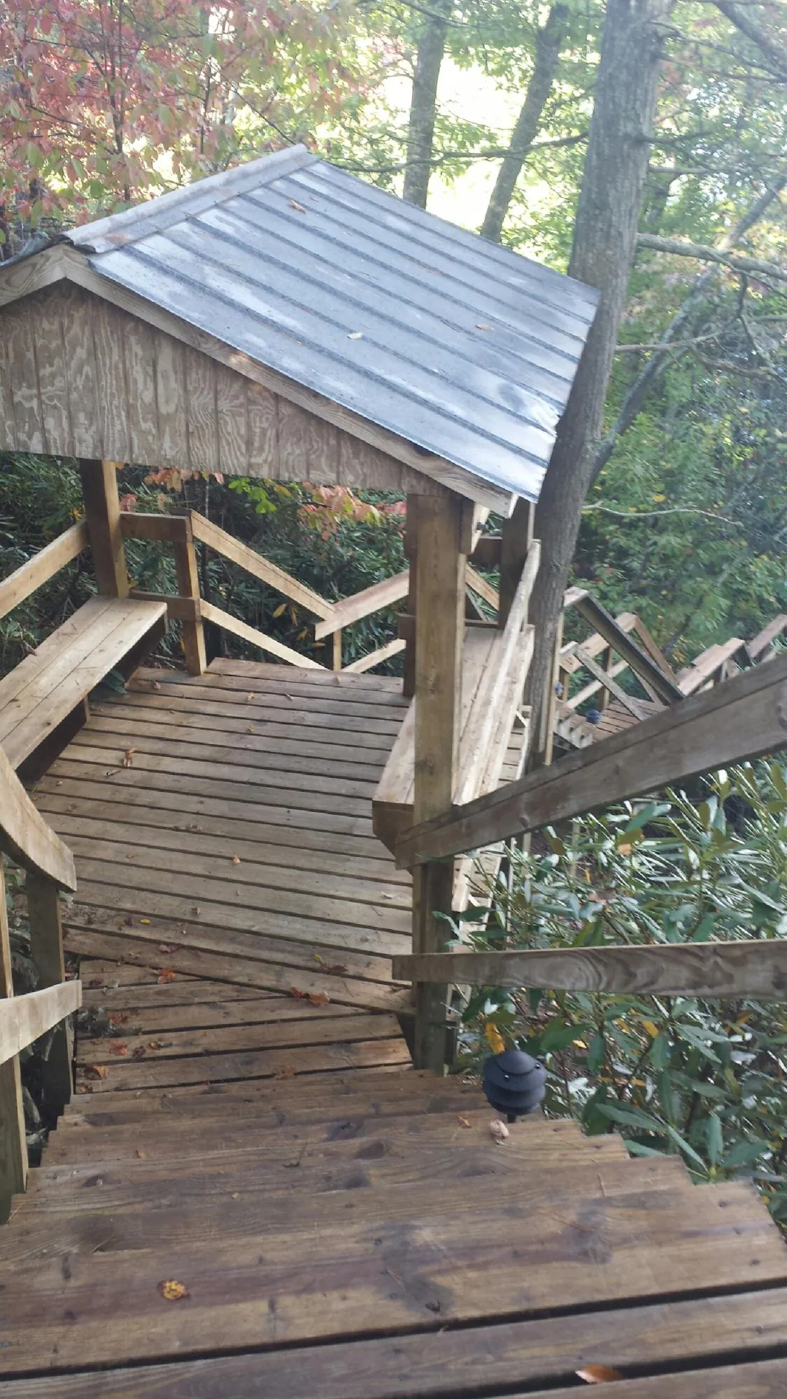 Metal roofed shelter over wooden steps on a wooded walkway — Skylight Repair & Installation work by our crew in Koppel