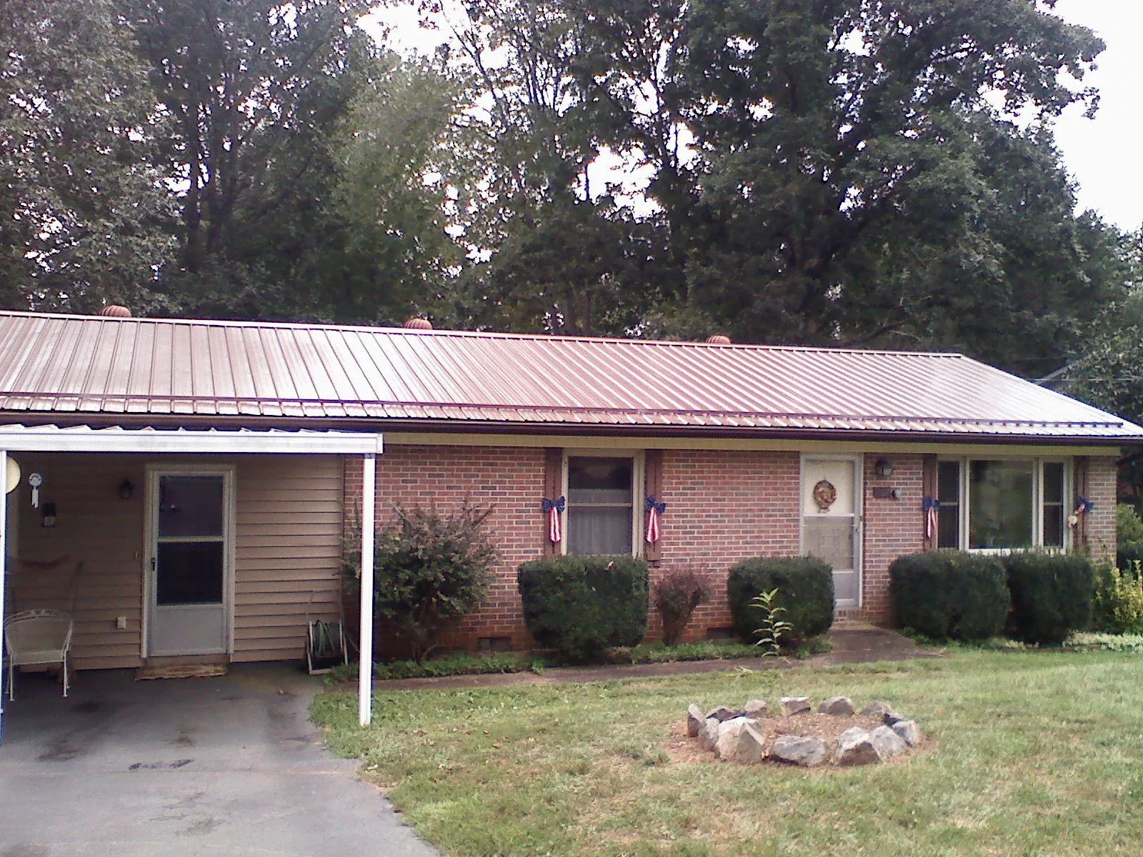Bronze metal roof and carport on a brick ranch home — Roof Repair work by our crew in Koppel